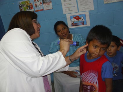 boy having ears examined by doctor