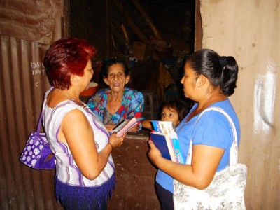 Two Women with books talking to a woman and child