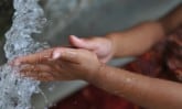 a child washing hands in water