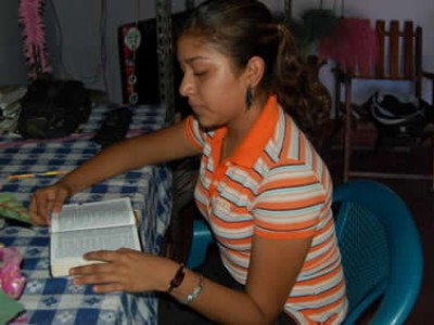 girl sitting at table reading Bible