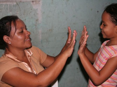 A woman and girl playing a game with their hands