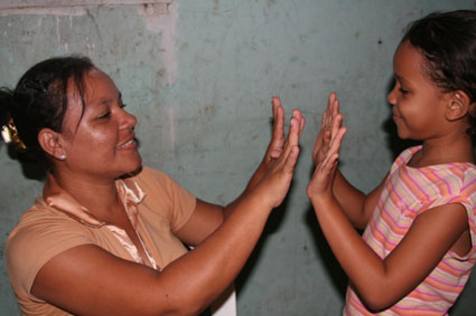 A woman and girl playing a game with their hands