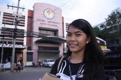 girl smiling in front of building