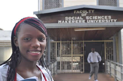 smiling girl in front of university with man walking in the background