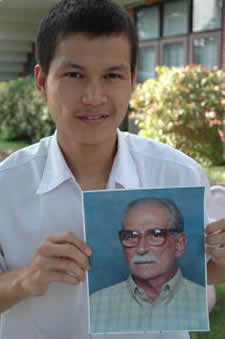 young man holding a picture of an older man