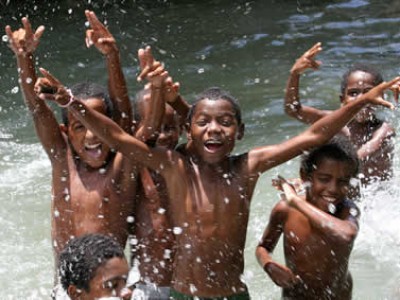 children splashing and playing in a body of water