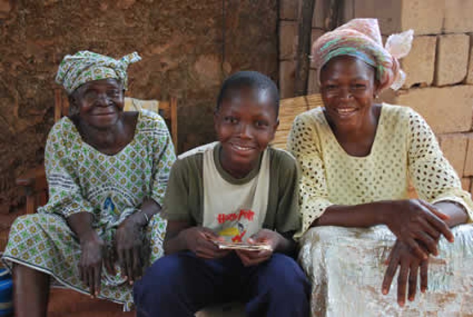 boy sitting with two women in Burkina Faso