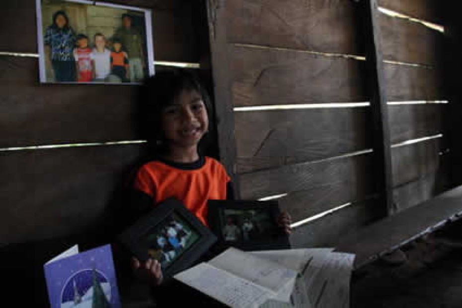 young smiling boy with photos and letters