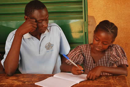 man sitting next to young girl writing letter