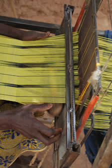 person weaving on a loom