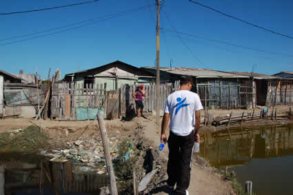 man walking on dyke in poor neighborhood