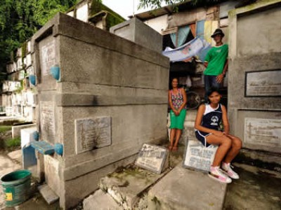 three people sitting on tombstones