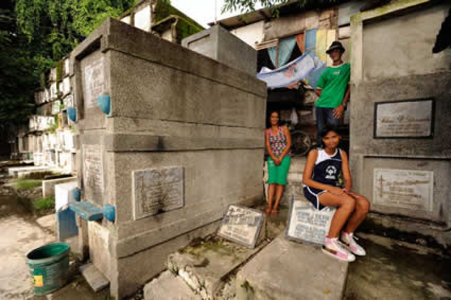 three people sitting on tombstones