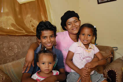 smiling woman sitting with boy and two girls