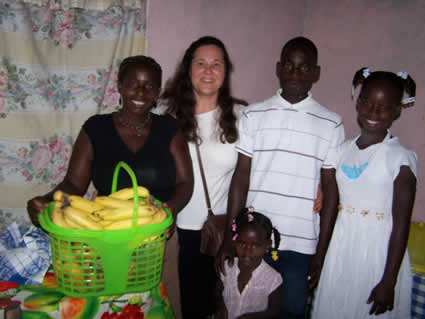 woman standing with a family with mom and three children, one of the women is holding a food basket