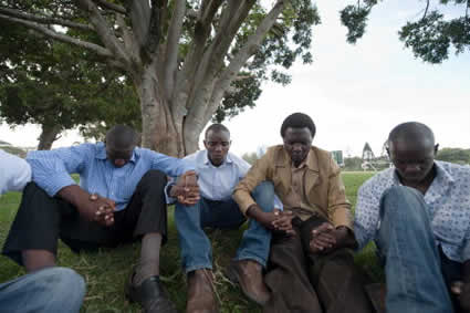 group of men holding hands and praying