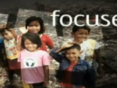 group of children smiling and waving