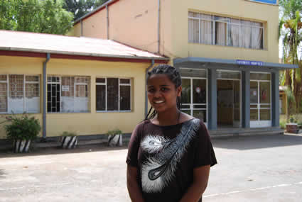 Ethiopian girl standing outside building