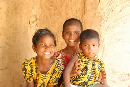two smiling girls with younger boy