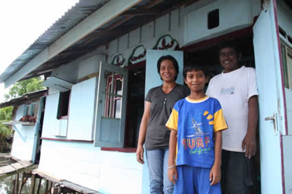 young boy with parents standing in doorway of a home