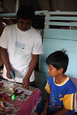 A man showing a boy how to solder