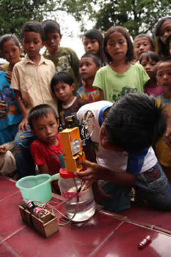 A boy shows a group of children something he made
