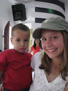 young girl holding a child wearing a red shirt