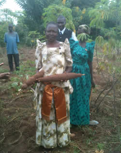 two women and two men holding cassava roots