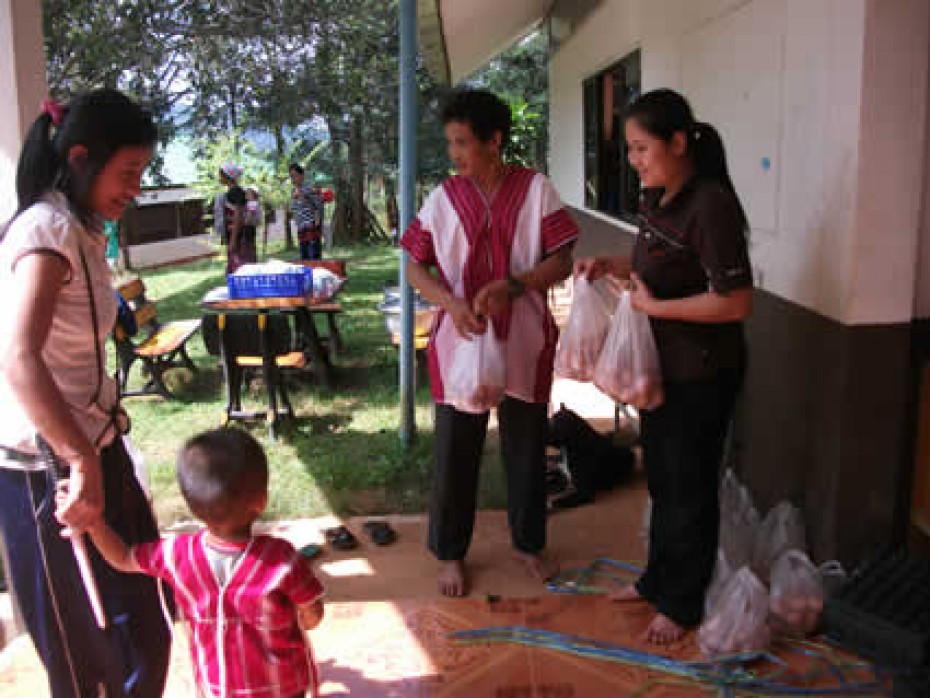 man and woman handing out bags of food