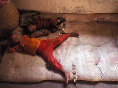 two small children sleeping on mat on floor