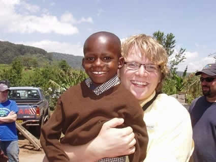 Young man holding a young boy both with big smiles on their faces