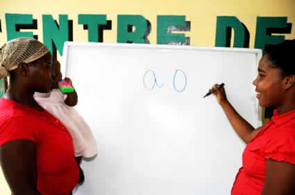 two women wearing red shirts next to a whiteboard