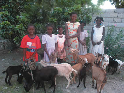 group of children with goats on ropes