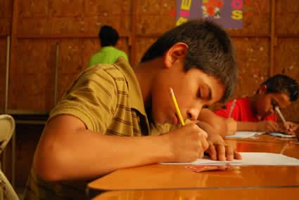 boy writing at school desk