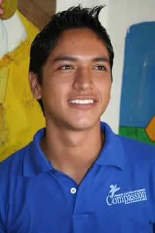 Young man in Mexico looking in the distance with a blue Compassion shirt