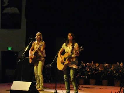 two girls playing guitars