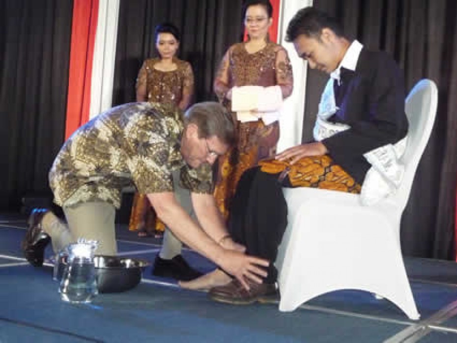 foot-washing Wess Stafford washes the feet of a Leadership Development Program graduate on stage