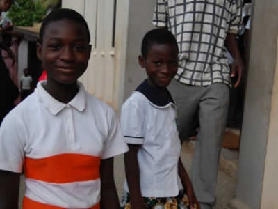 two children standing in front of a doorway