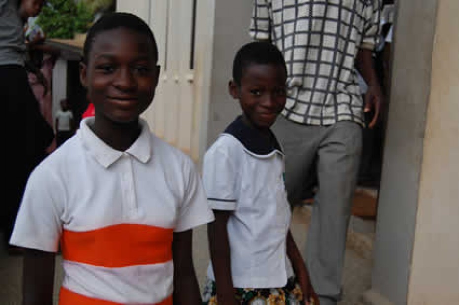 two children standing in front of a doorway