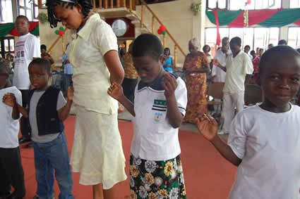 group of adults and children praying