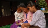 three young girls reading a letter
