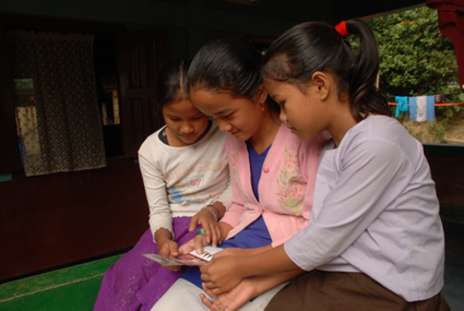 three young girls reading a letter