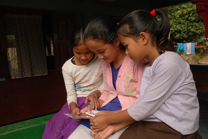 three girls reading a letter