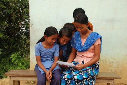 children gathered around reading a letter