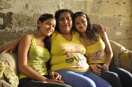 woman sitting on couch with two young girls