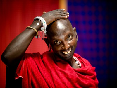 Kenyan man in traditional dress with hand on head