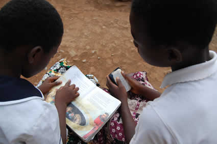 two boys looking at a book