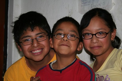 a girl and two boys smiling