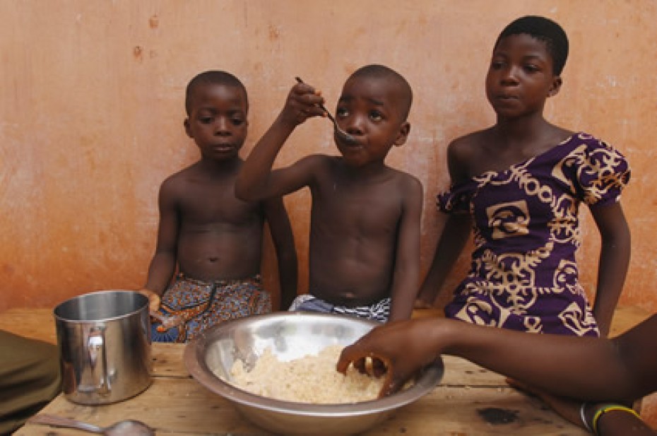 three children eating from large bowl