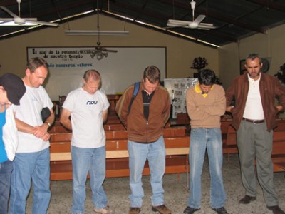 men standing inside a church praying